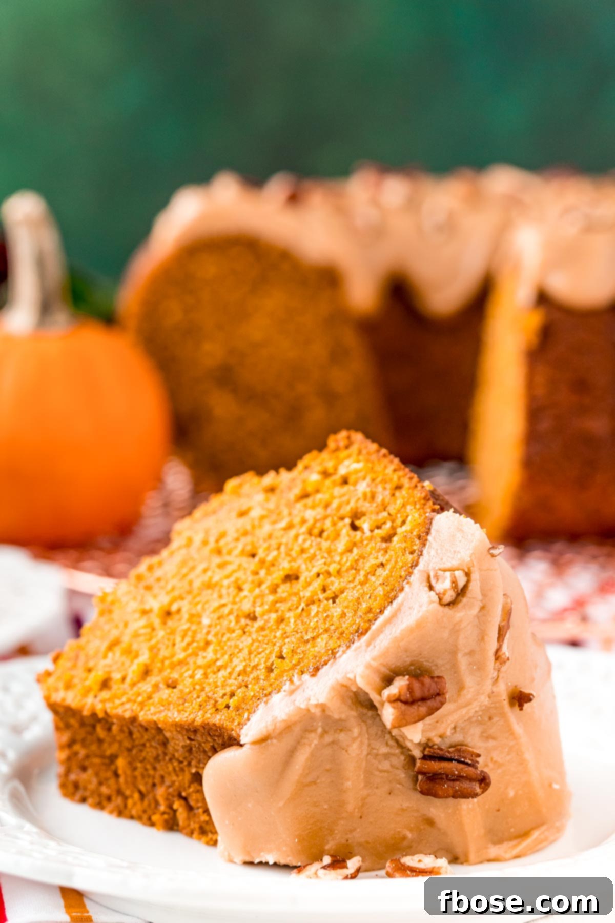 Slice of pumpkin bundt cake on a white plate.