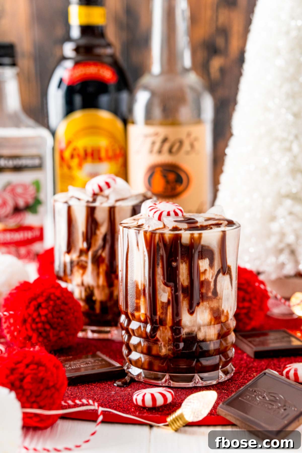 Two chocolate peppermint white russians on a table with christmas decorations.