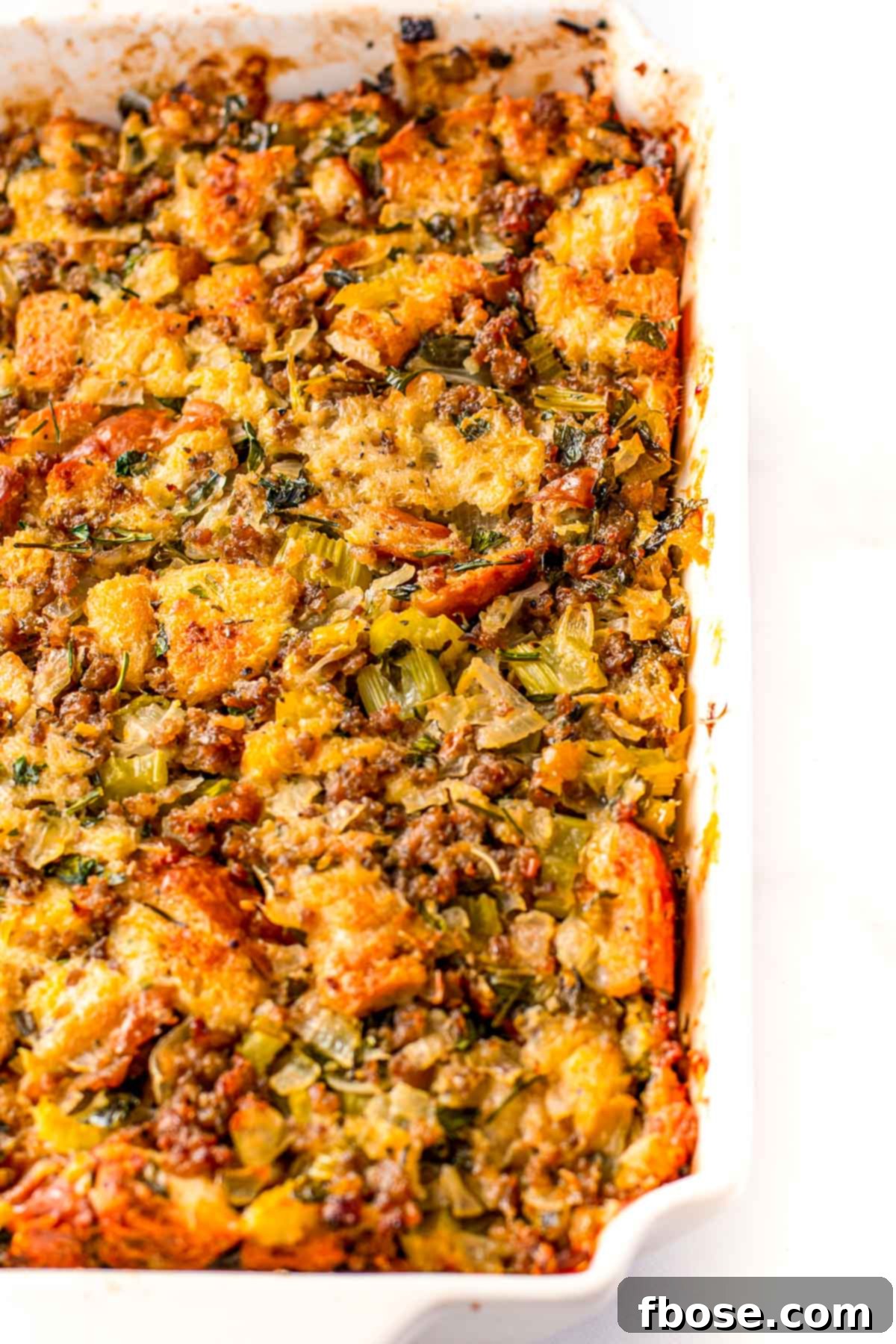 Ultimate Sausage Stuffing 8 Overhead close up photo of a baking dish filled with a rich, golden-brown sausage dressing, showcasing its inviting texture.