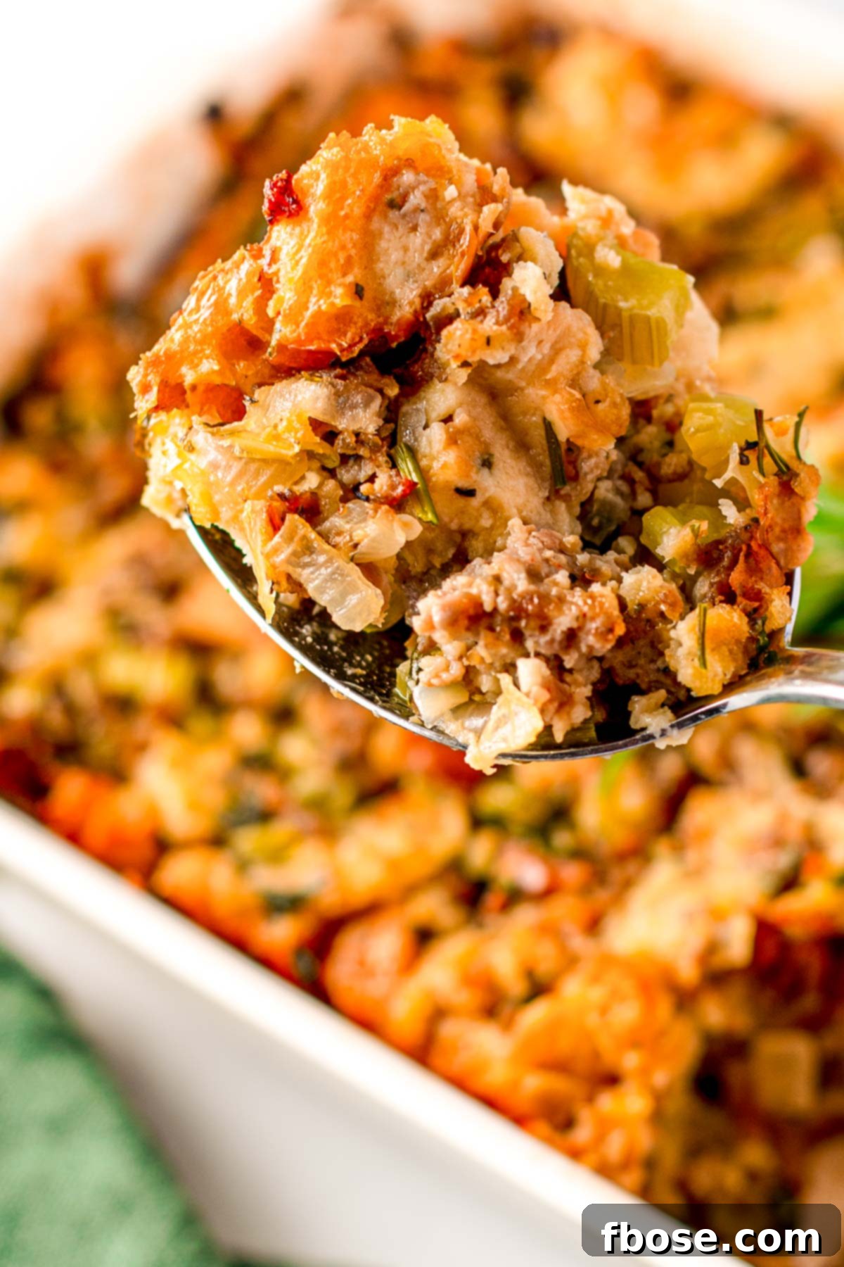Ultimate Sausage Stuffing 9 Serving spoon with a generous scoop of flavorful sausage stuffing, showcasing its moist and tender texture.