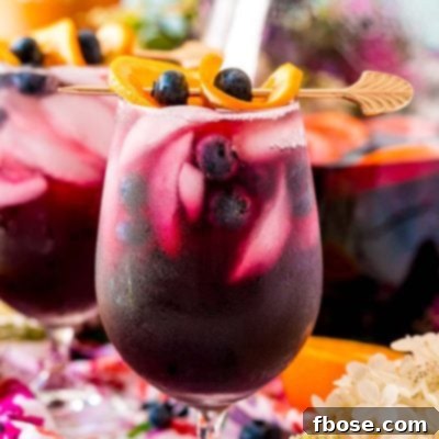 Close up photo of blueberry sangria in wine glasses and in a serving pitcher.