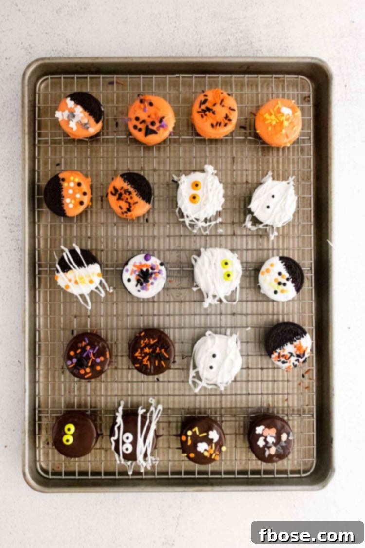 Halloween decorated Oreos on a baking sheet.