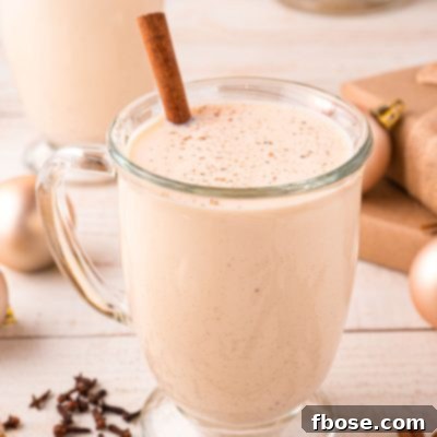 Close up photo of a mug of homemade eggnog on a light wooden counter.