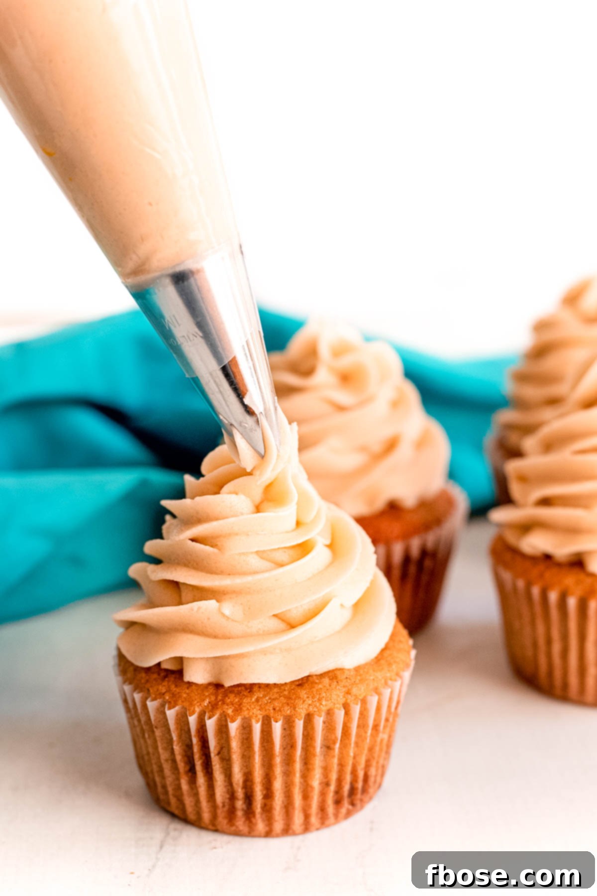 Simple Brown Sugar Delight 3 Close-up image of creamy brown sugar frosting being piped elegantly onto a freshly baked cupcake.