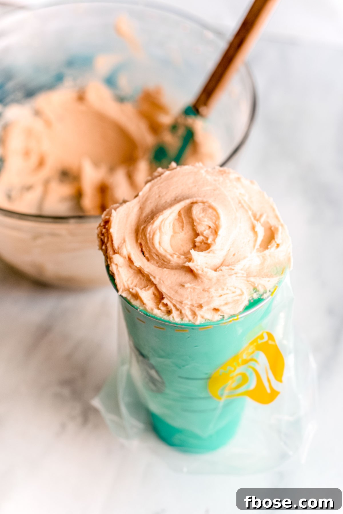 Simple Brown Sugar Delight 8 Brown sugar frosting being carefully transferred into a pastry bag, ready for piping onto desserts.