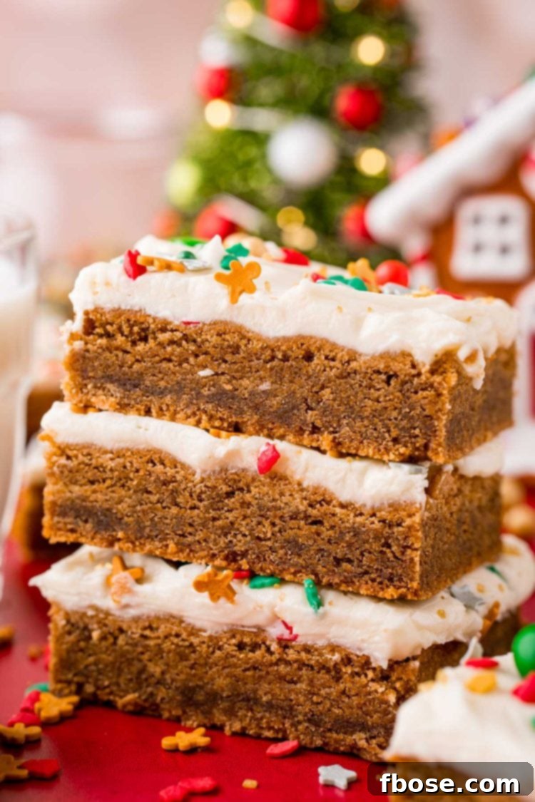 Close up photo of a stack of three gingerbread bars with cream cheese frosting.