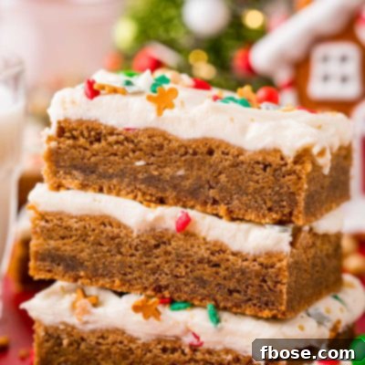 Close up photo of a stack of three gingerbread bars with cream cheese frosting.