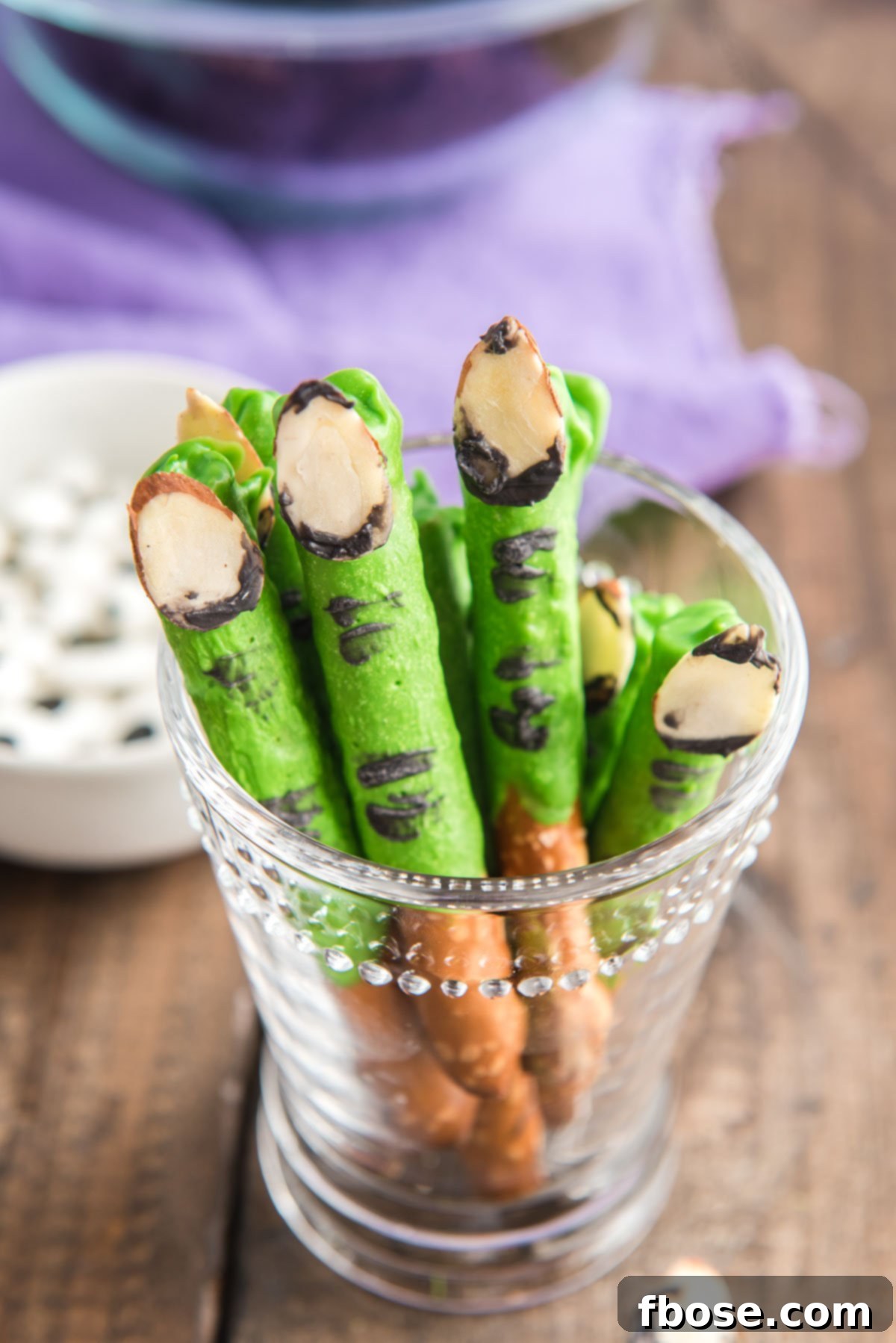 Halloween monster finger pretzels in a clear glass.