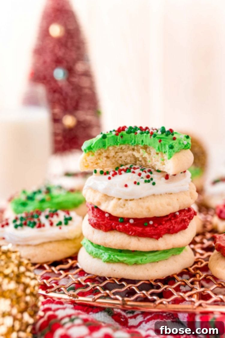 A stack of beautifully round sugar cookies on a copper wire cooling rack, with one cookie playfully missing a bite, suggesting its irresistible taste.