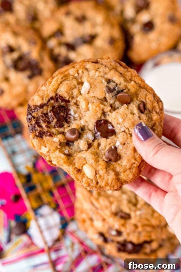 A woman's hand holding a Ranger Cookie to the camera.