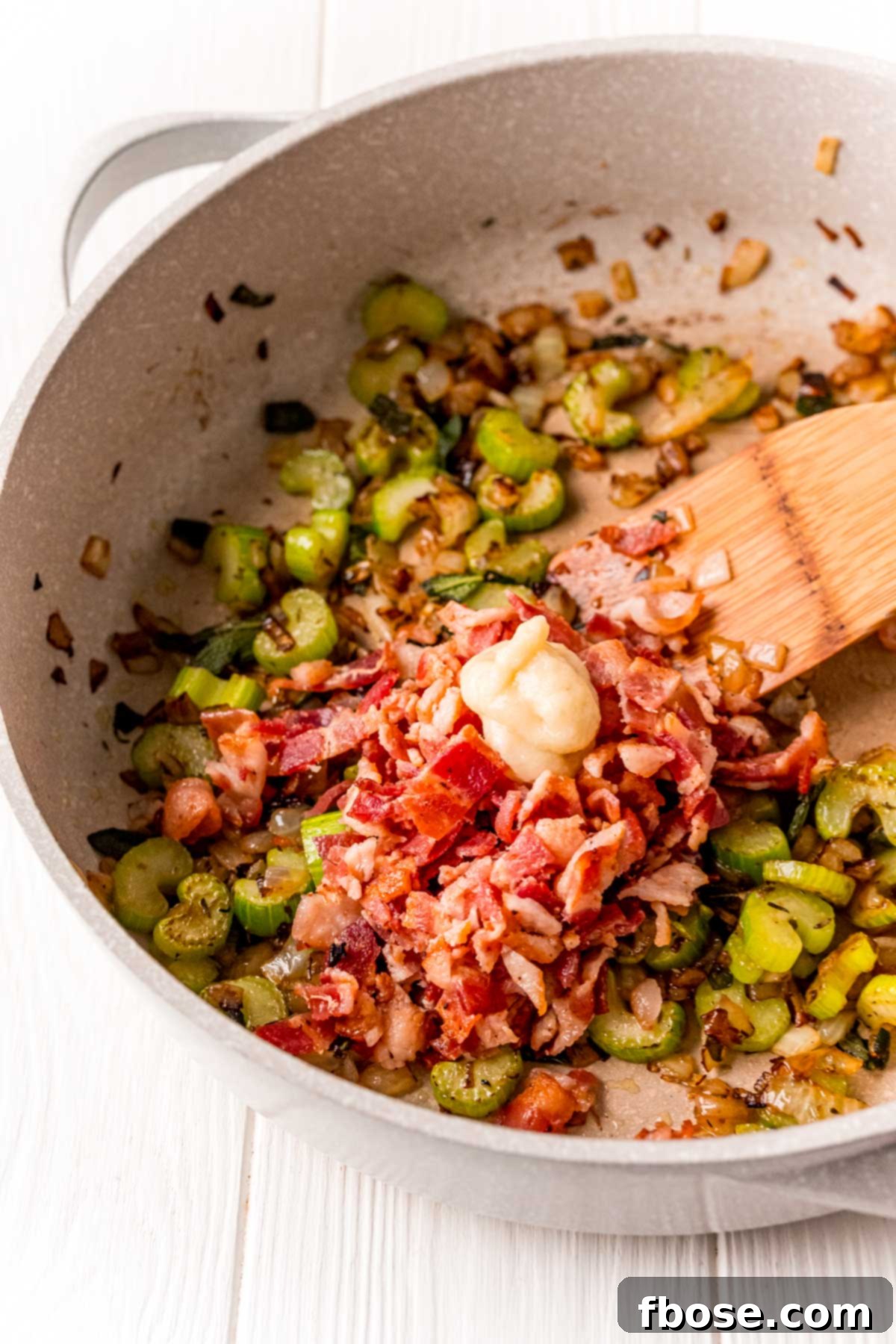 The Ultimate Cornbread Dressing 4 Diced celery, onions, crispy bacon, and fragrant garlic paste sizzling in a skillet, building the flavor base for the dressing.