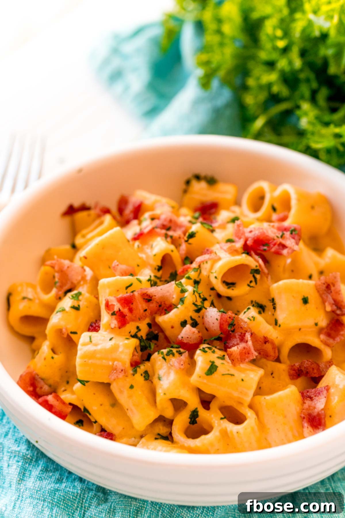 Close up photo of butternut squash mac and cheese topped with baco