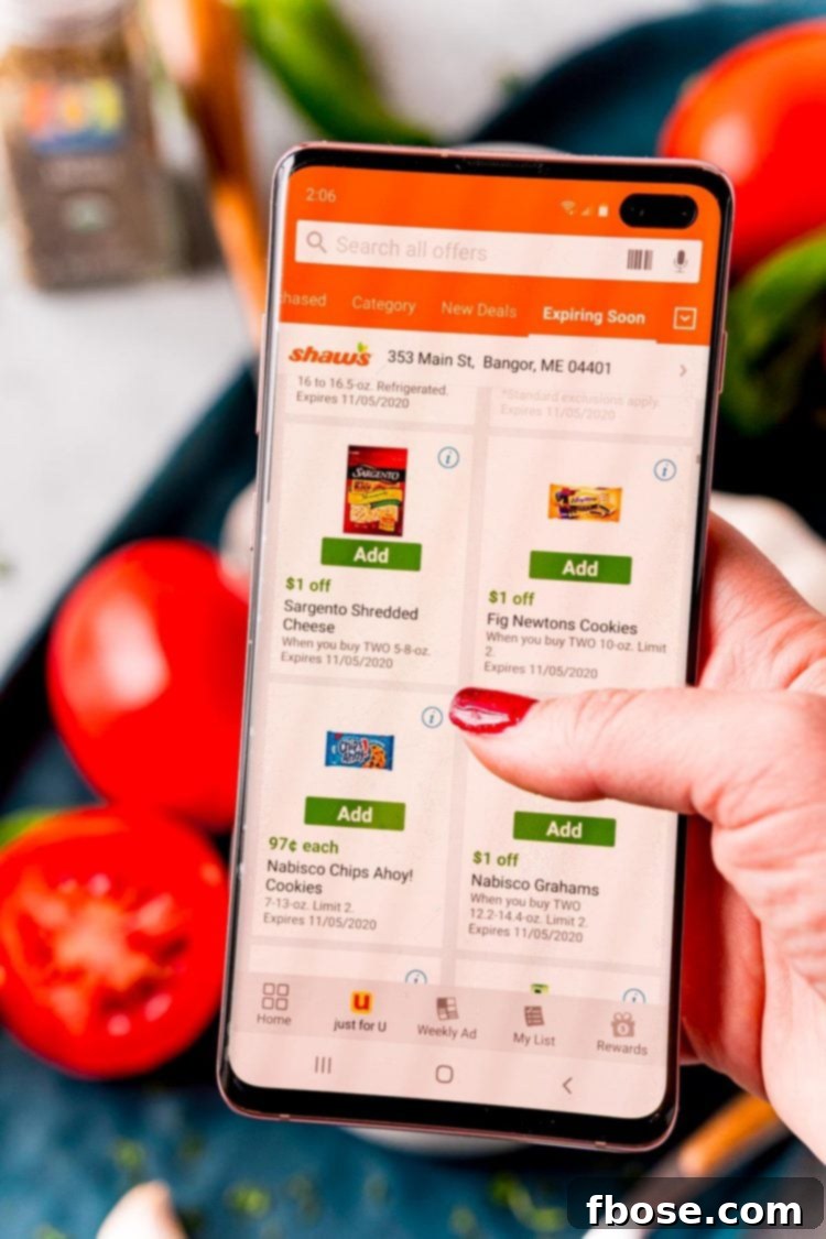 Woman's hand holding a cell phone with the Shaw's Supermarket app pulled up.