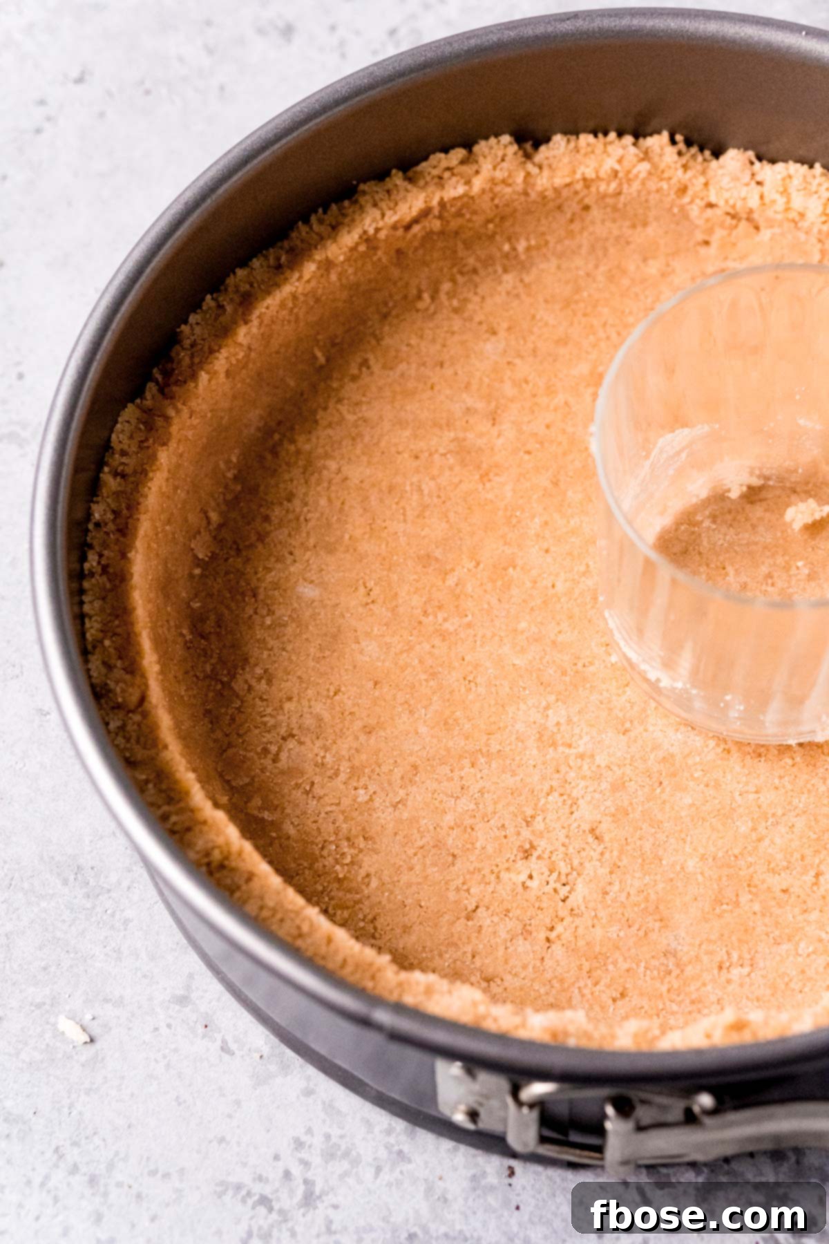 A golden shortbread cookie crust, perfectly pressed into a springform pan, ready for the filling.