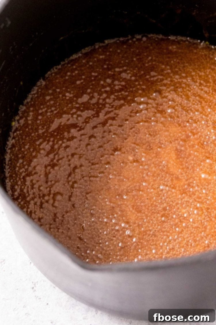 A vibrant close-up shot of the butter and sugar mixture vigorously boiling in a nonstick pot, showcasing the rich caramelization process.