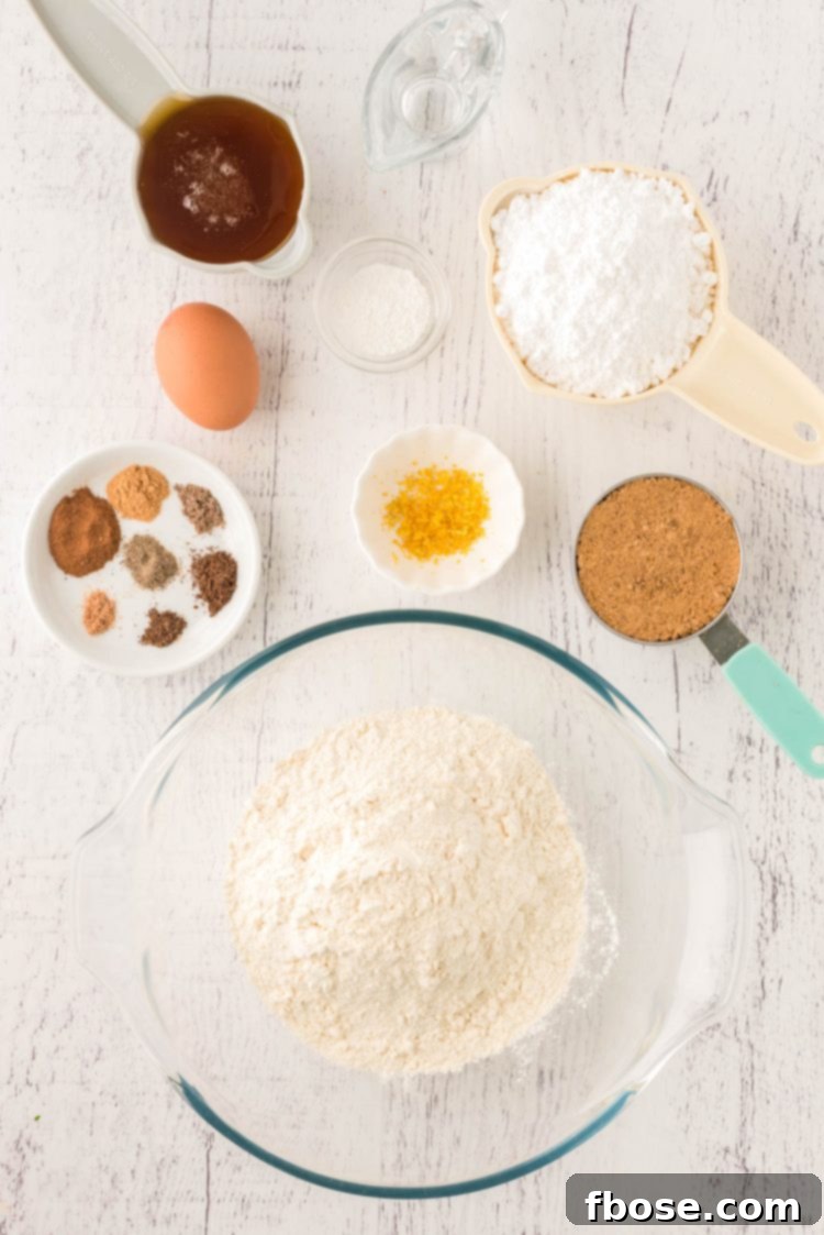 Overhead photo of the ingredients to make pfeffernusse cookies on a white wooden table.