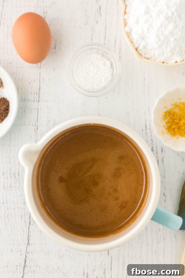 Overhead photo of a pot with melted brown sugar and honey in it with other ingredients around it.