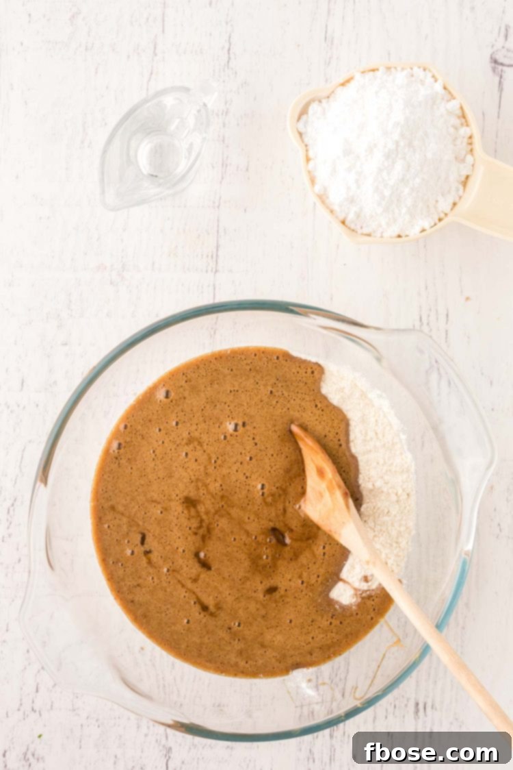 Ingredients being mixed in a glass mixing bowl to make cookies.
