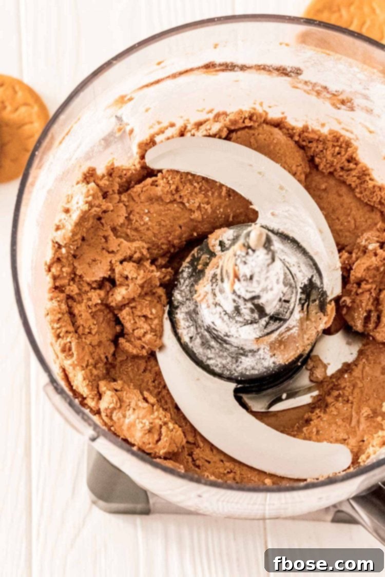 The blended gingerbread truffle mixture in a food processor bowl, showing its uniform and dough-like consistency.