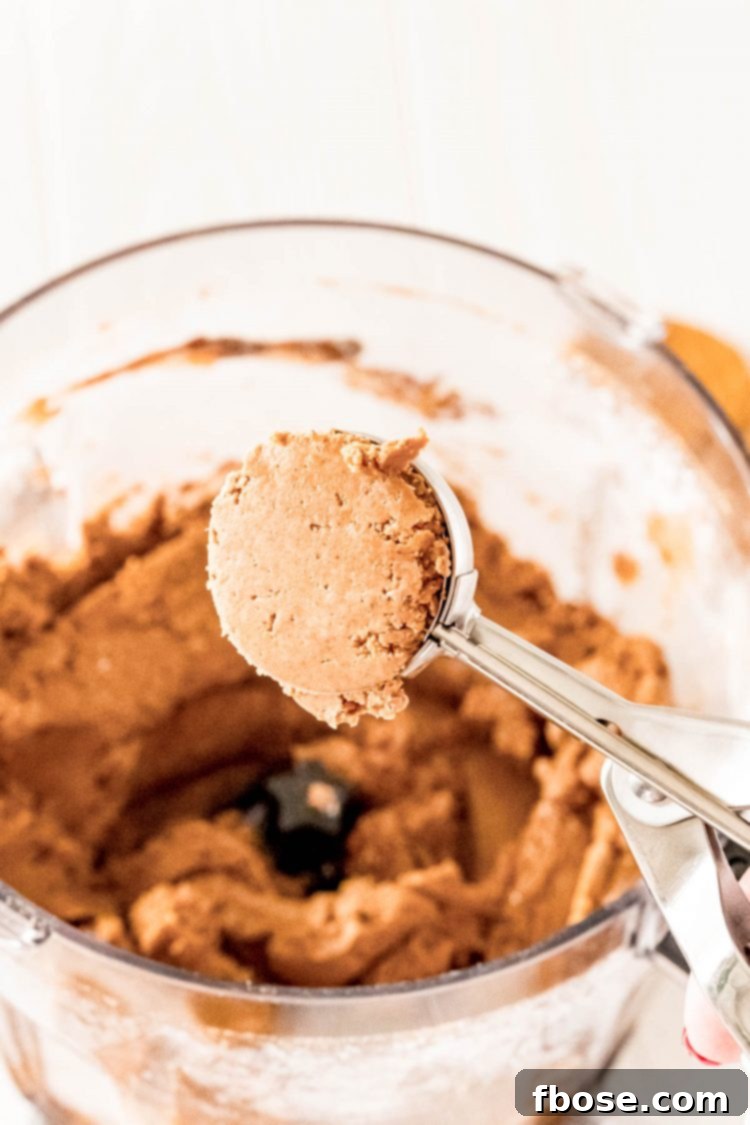 A medium cookie scoop used to portion out the gingerbread truffle mixture, ready to be rolled into balls.