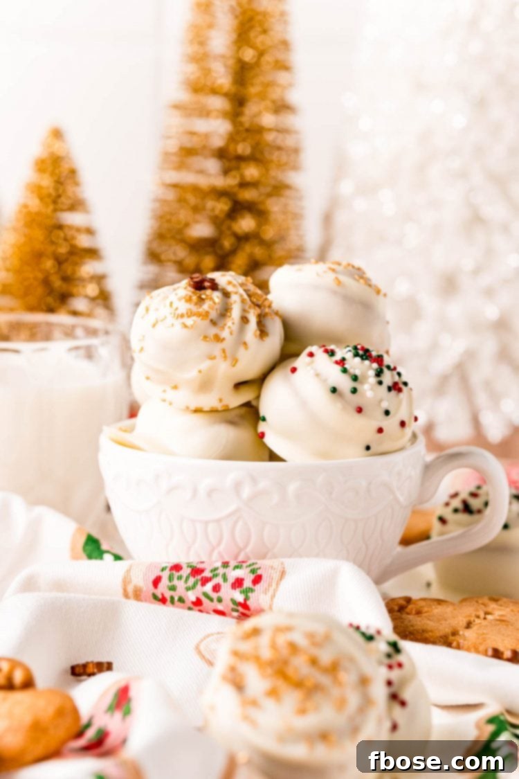 White chocolate covered gingerbread truffles artistically arranged in a white mug, ready for serving or gifting.