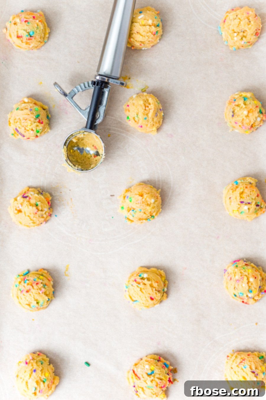 A single Birthday Cake Pudding Cookie with sprinkles on a wooden surface, highlighting its homemade appeal.