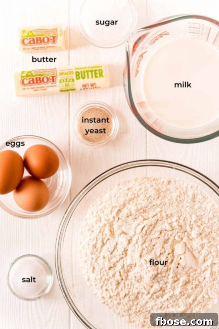 Ingredients to make parker house dinner rolls on a white wood table.