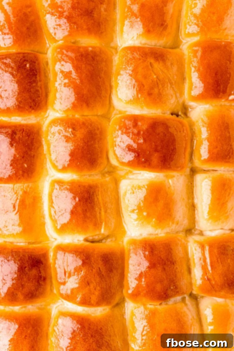 Overhead photo of a pan of dinner rolls that have been brushed with butter.
