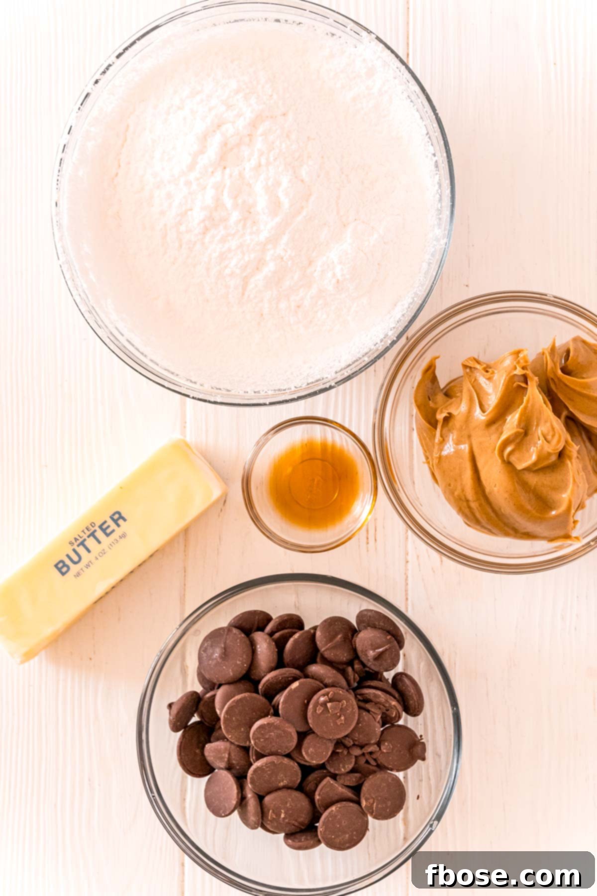 Overhead photo of all the simple ingredients required to make Peanut Butter Buckeyes laid out on a clean white table.