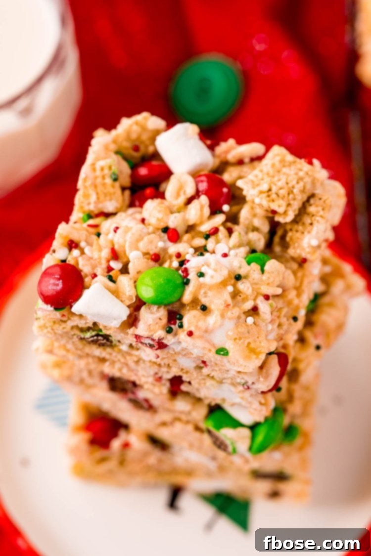 Close up photo of a stack of rice krispie treats with m&ms, showcasing their festive colors and gooey texture.