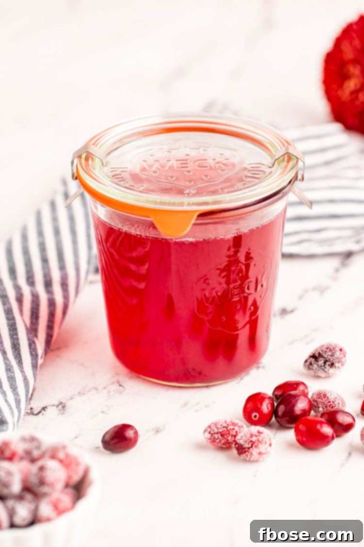 Ruby Red Elixir 6 A glass Weck jar, elegantly sealed with a lid, holds the freshly made cranberry simple syrup, ready for storage or immediate use.