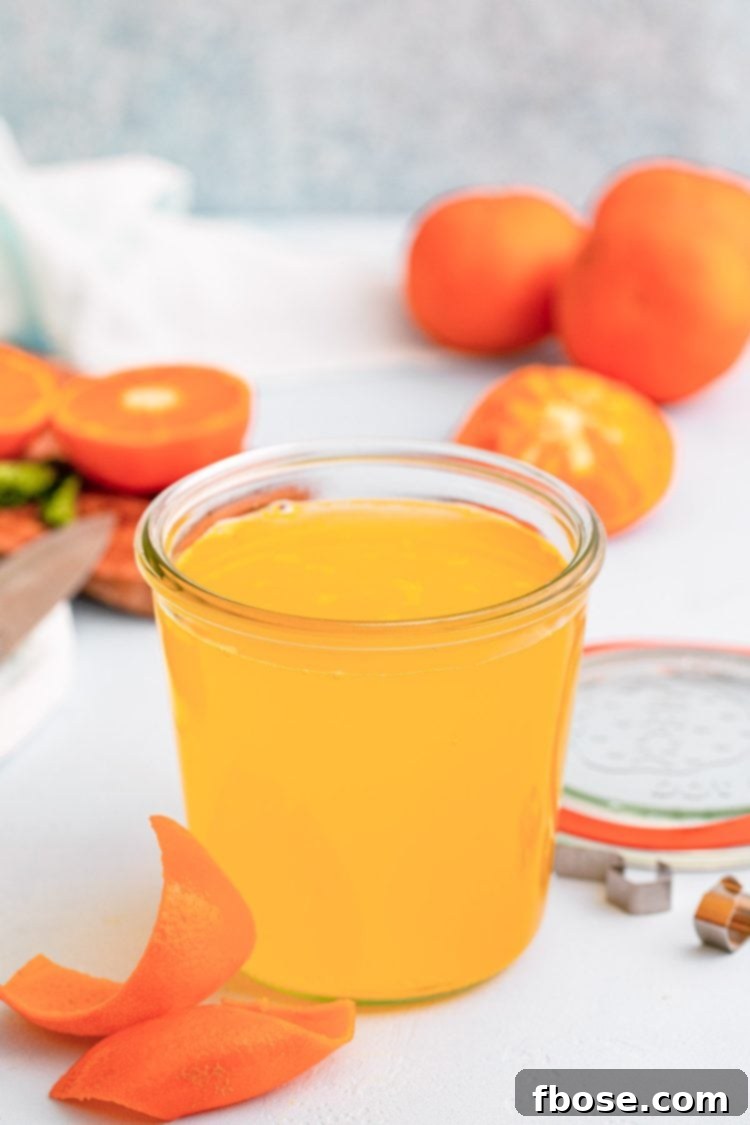 Close up photo of homemade orange simple syrup in a bottle, ready to be used in drinks.