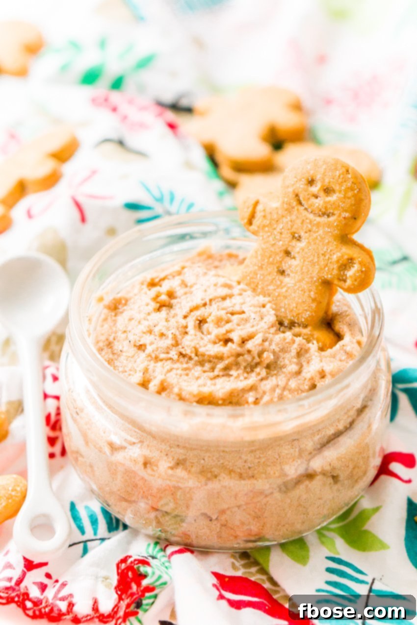 Decadent Gingerbread Skin Polish 2 A festive jar of homemade whipped gingerbread sugar scrub, garnished with a small gingerbread man cookie, perfect for holiday gifting.