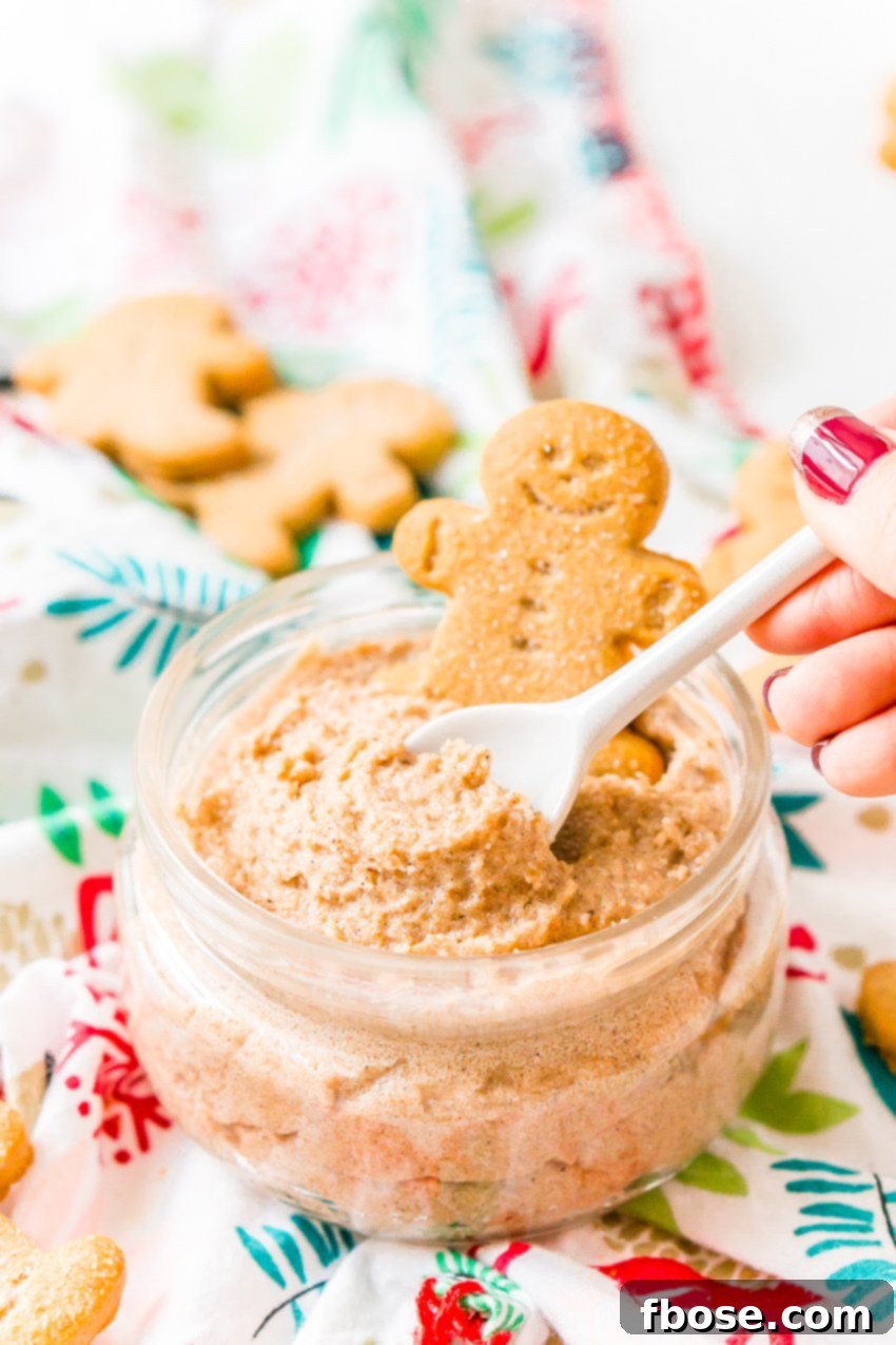 Decadent Gingerbread Skin Polish 6 A wooden spoon rests in a jar of gingerbread sugar scrub, with a tiny gingerbread man resting on the rim, emphasizing its festive appeal.