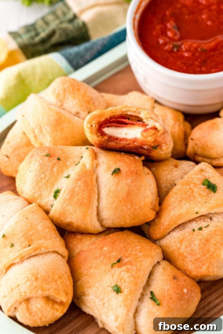 Quick Cheesy Pizza Pinwheels 5 Stuffed Pizza Rolls piled high on a rustic serving board, ready to be enjoyed as a snack or appetizer.