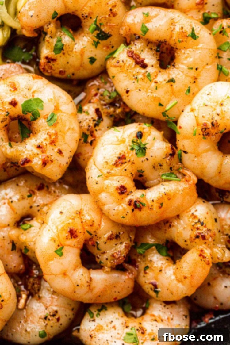 Close up photo of perfectly sauteed shrimp in a hot skillet, ready to be combined with zucchini noodles.