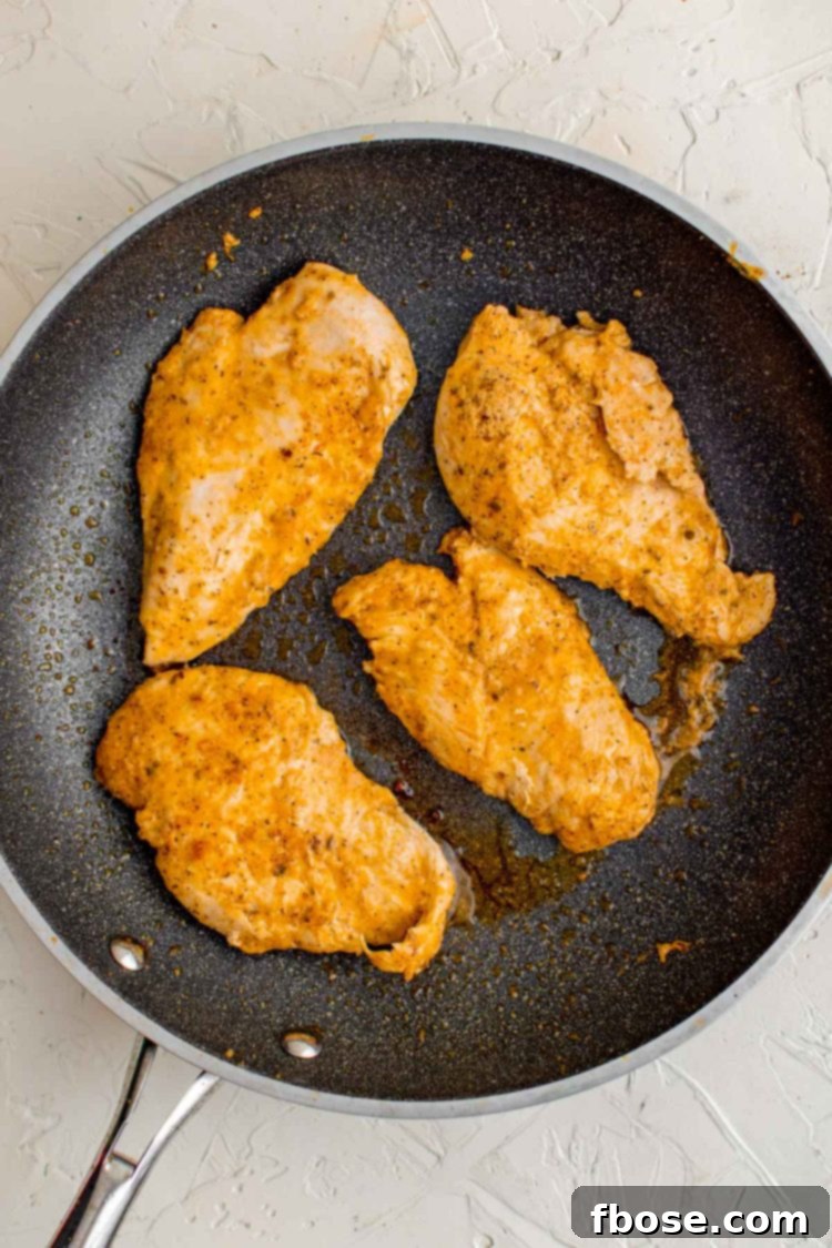 Chicken cooking in a skillet to make chicken gyros.