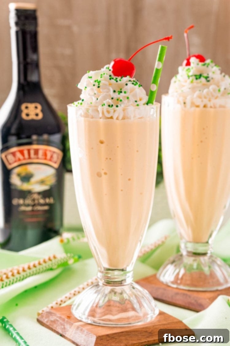 Effortless Irish Cream Indulgence 4 Two Irish cream milkshakes on wood coasters on a green napkin with a bottle of Bailey's in the background.
