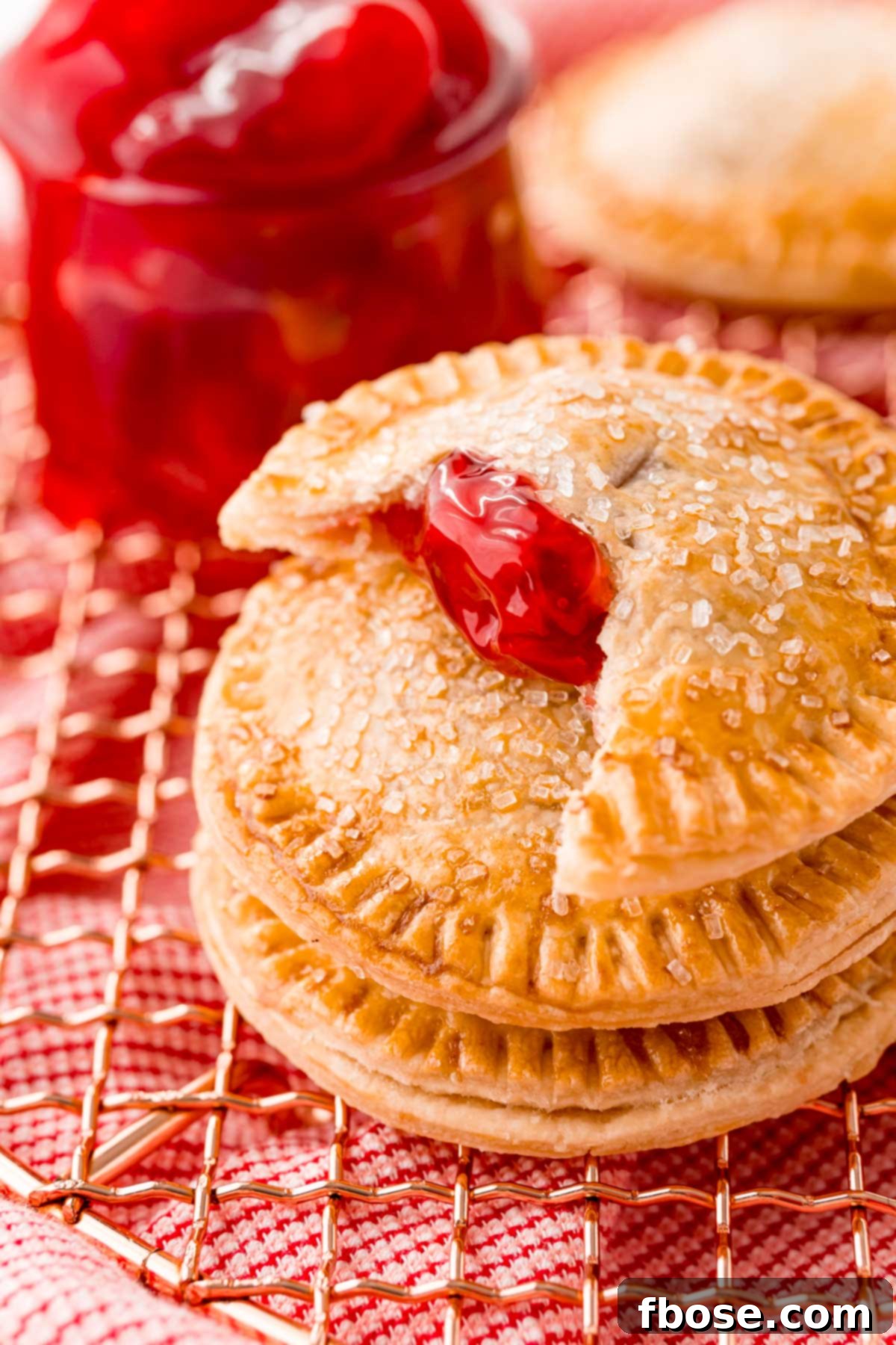 Close up photo of cherry hand pies on a copper wire rack. A delicious and easy Air Fryer dessert.