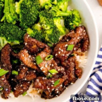 Overhead photo of mongolian beef with broccoli and rice in a white bowl.