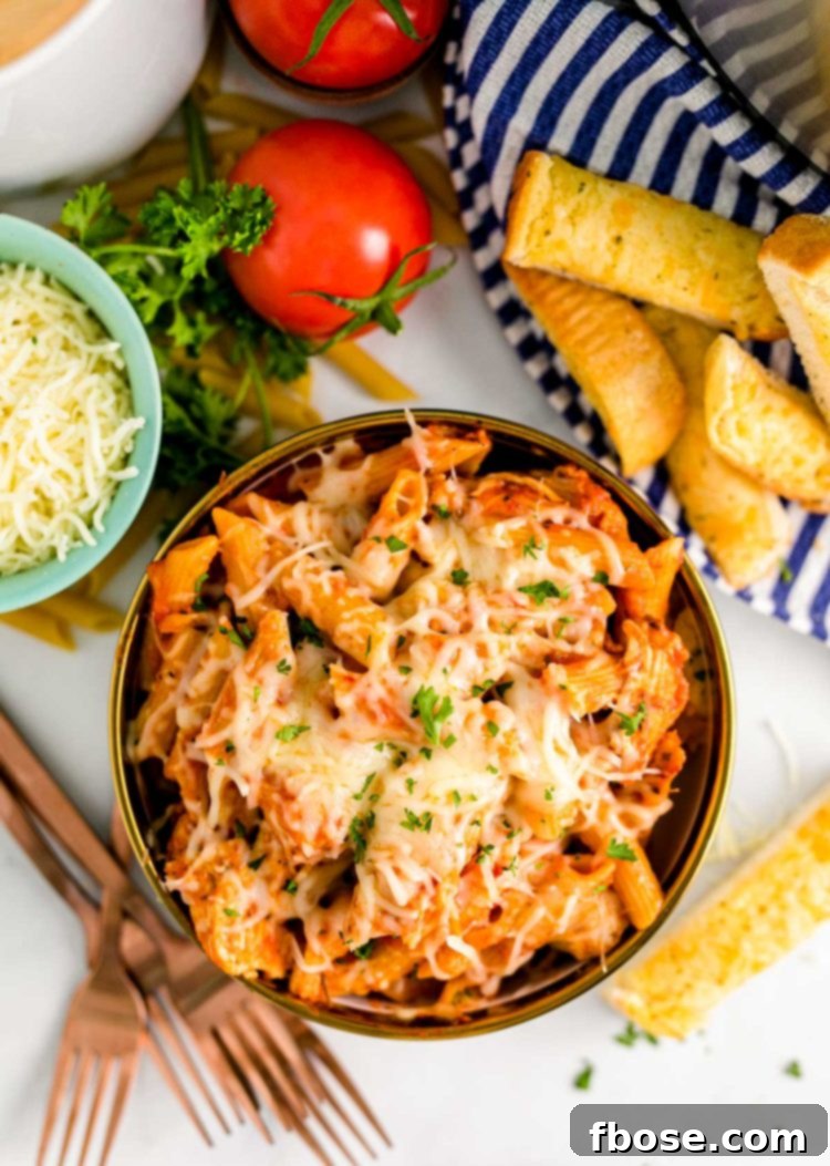 Overhead shot of a vibrant bowl of Instant Pot Chicken Parmesan Pasta, garnished with fresh parsley.