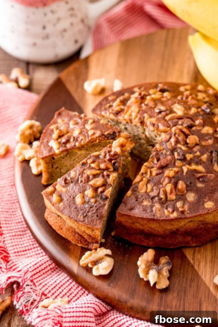 A perfectly round loaf of golden-brown air fryer banana bread resting on a rustic wooden cutting board, showcasing its enticing crisp exterior.