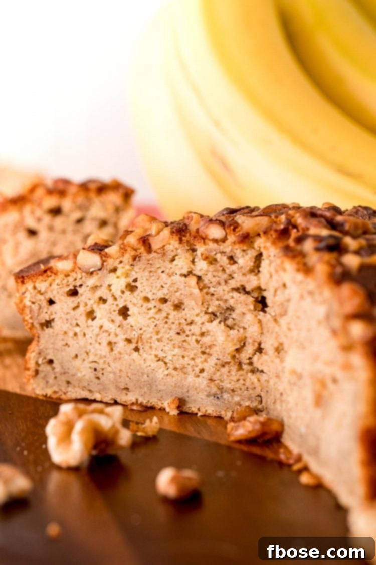 A close-up view of a round loaf of air fryer banana bread, with several slices already removed to reveal the fluffy and moist interior texture.