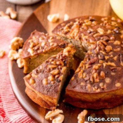A round loaf of banana bread that's been cooked in the air fryer on a wooden cutting board.