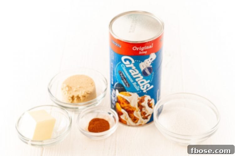 Ingredients for air fryer monkey bread neatly arranged on a white table: cinnamon rolls, butter, sugars, and cinnamon.