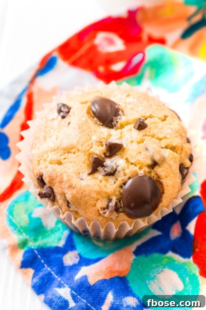 Close up photo of a chocolate chip muffin on a colorful napkin.