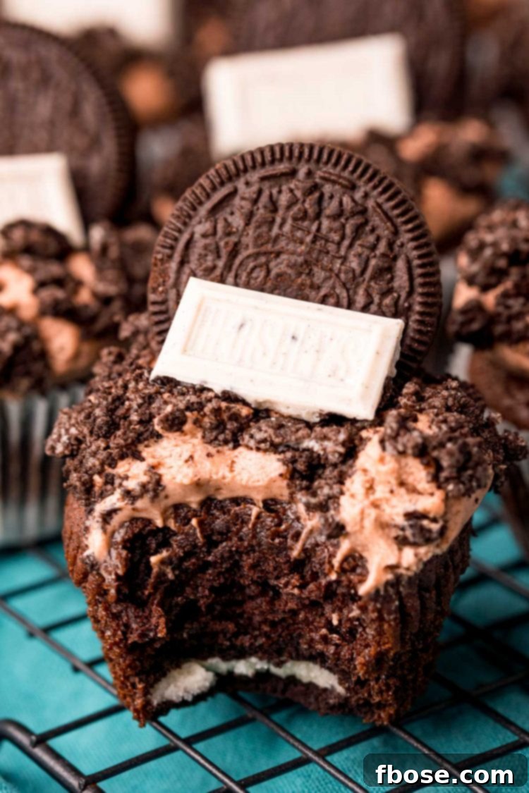 Close up photo of an Oreo Cupcake with a bite taken out of it, revealing the Oreo base.