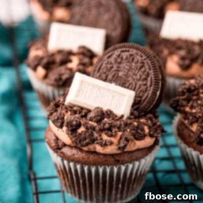 Close up of Oreo Cupcakes on a wire rack on a blue napkin.