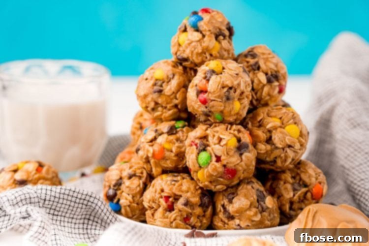Finished monster cookie energy balls arranged on a white plate on a gray napkin, looking ready to eat.