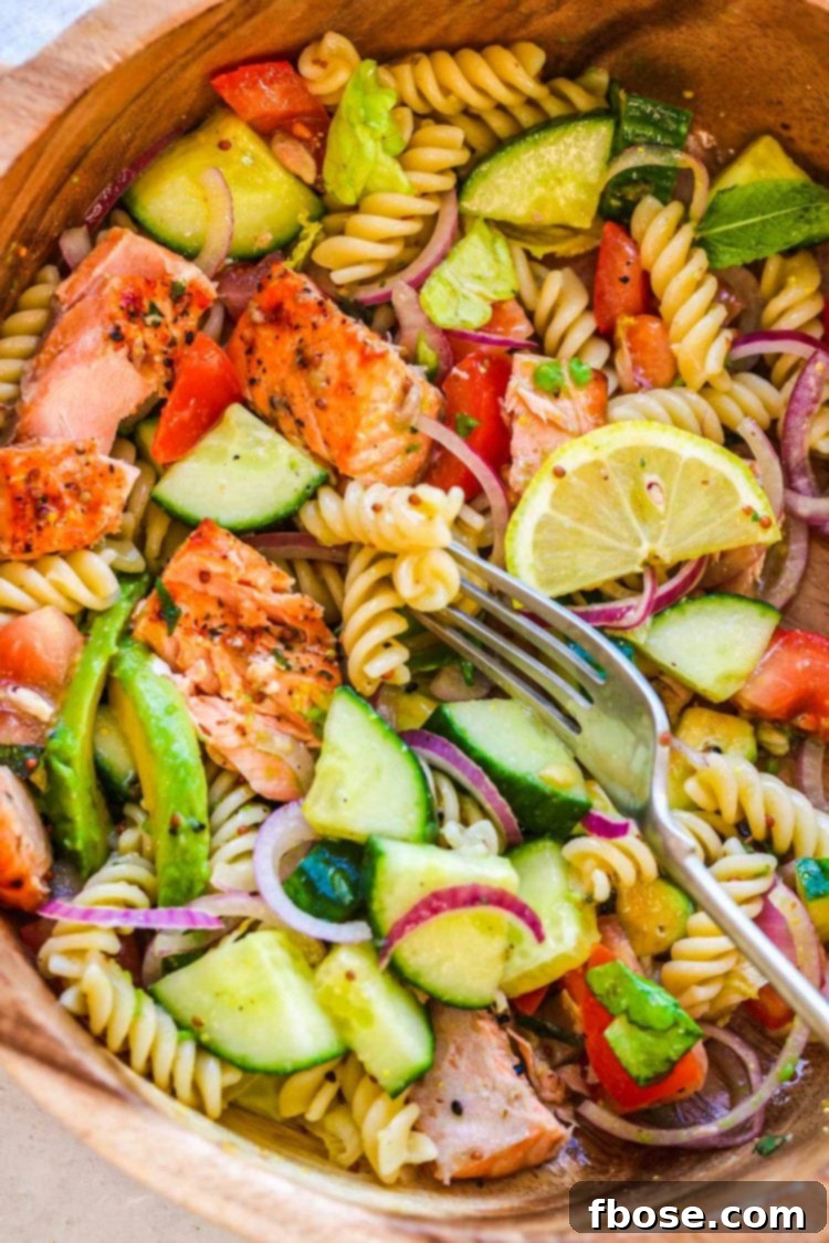 Overhead photo of a wooden serving bowl with salmon pasta salad in it.
